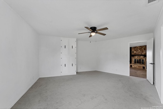 empty room with carpet floors, visible vents, and a ceiling fan