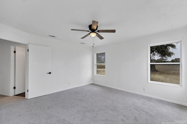 empty room with carpet floors, ceiling fan, and visible vents