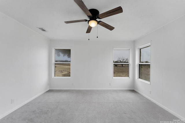 empty room with baseboards, visible vents, plenty of natural light, and carpet flooring