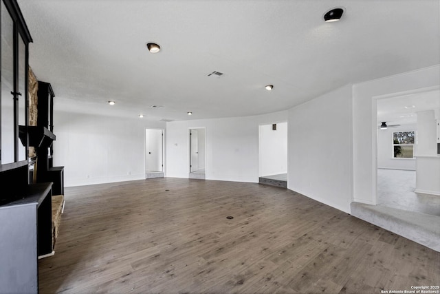 unfurnished living room featuring wood finished floors, visible vents, and a ceiling fan