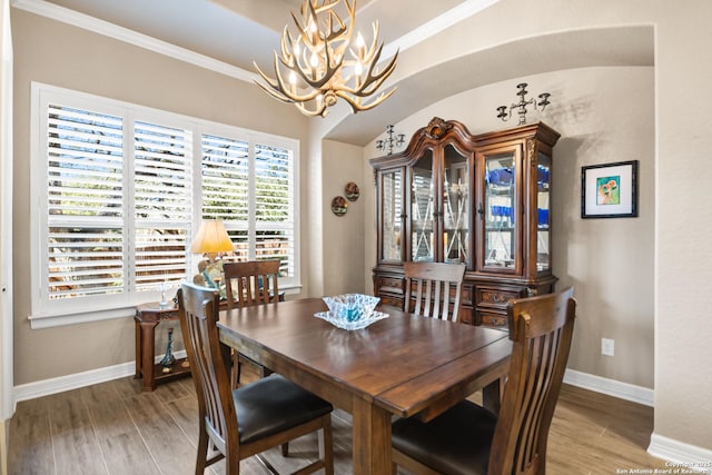 dining room featuring ornamental molding, wood finished floors, and baseboards