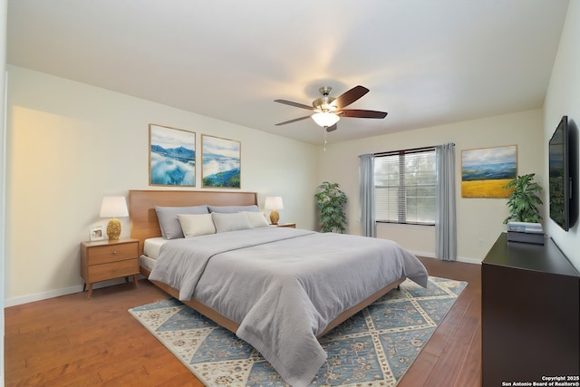 bedroom with ceiling fan, baseboards, and wood finished floors