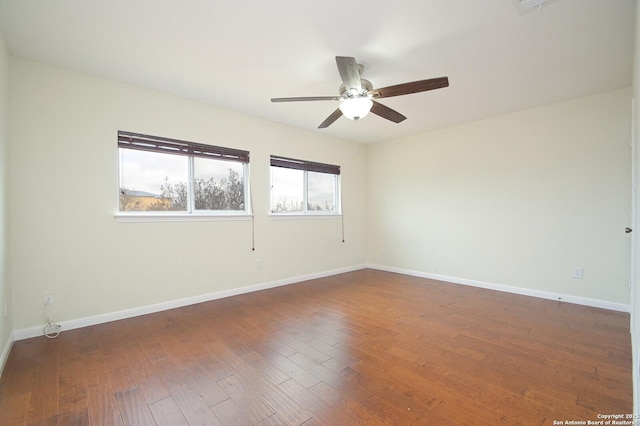 empty room with ceiling fan, baseboards, and wood finished floors