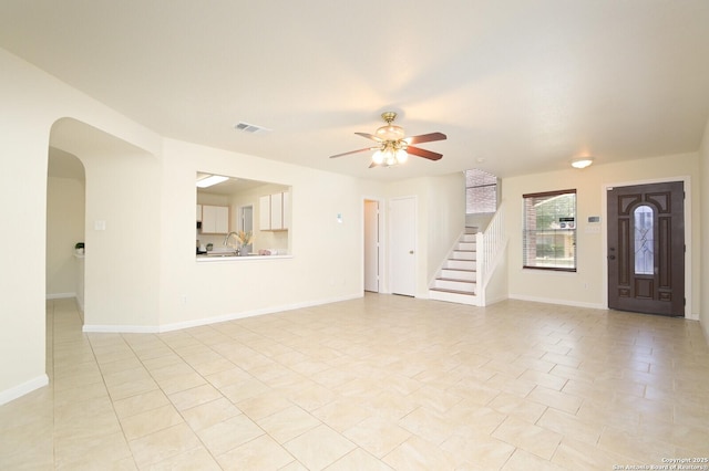 interior space with stairs, baseboards, visible vents, and a ceiling fan