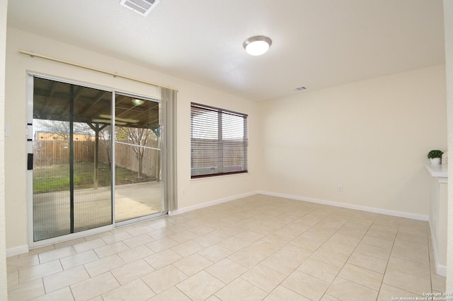 spare room featuring baseboards, visible vents, and tile patterned floors