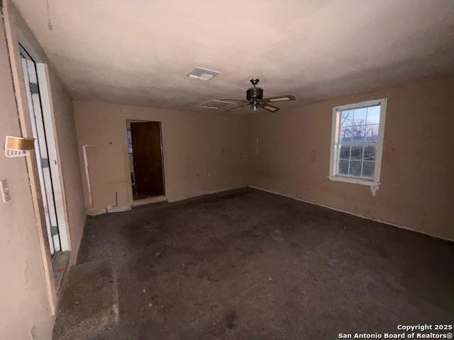 empty room featuring a ceiling fan, concrete flooring, and visible vents