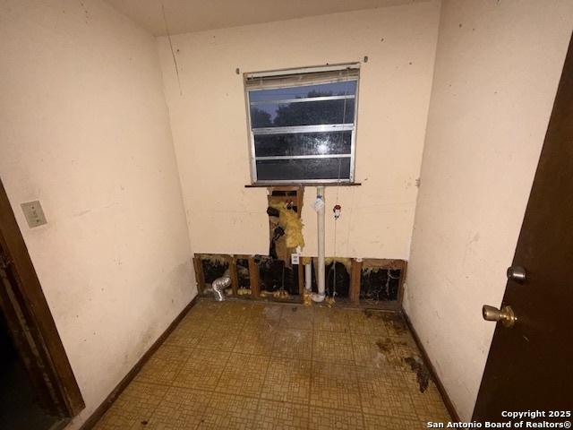 spare room with baseboards and tile patterned floors