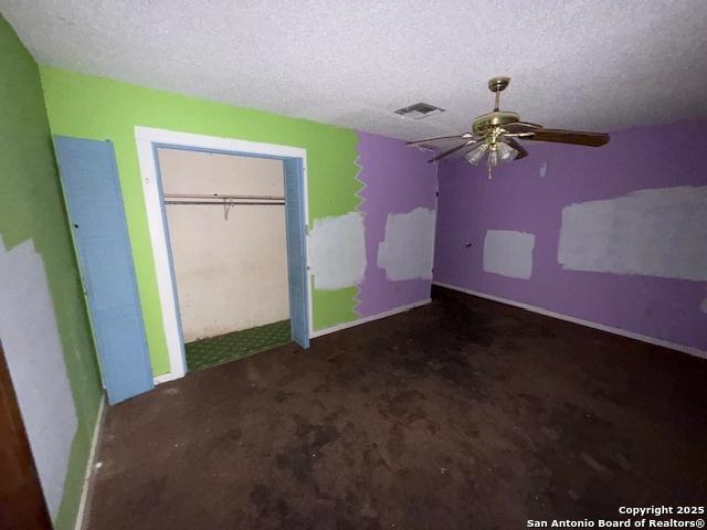 unfurnished bedroom featuring baseboards, carpet, visible vents, and a textured ceiling