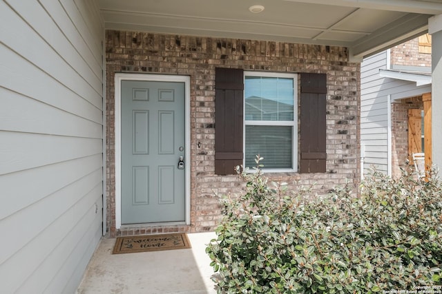 doorway to property featuring brick siding