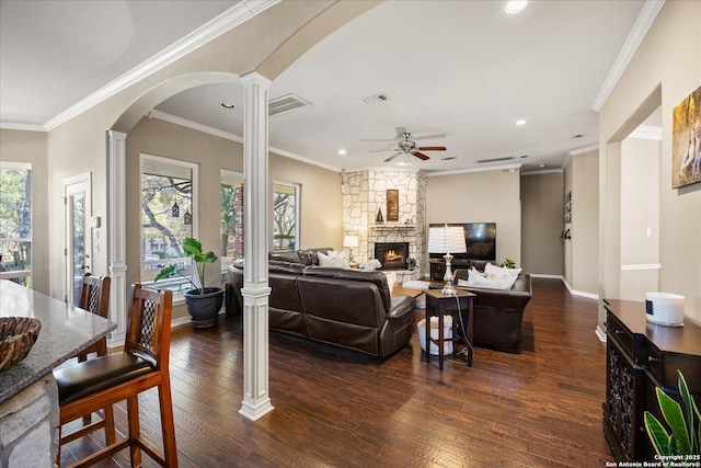 living area with dark wood-type flooring, a fireplace, visible vents, and ornate columns