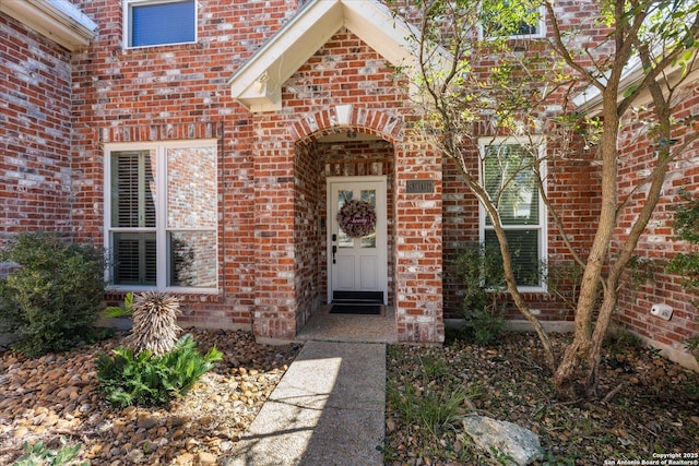 view of exterior entry with brick siding