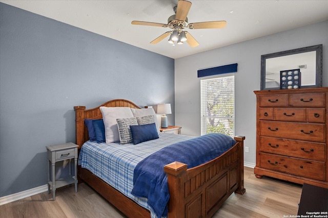 bedroom with light wood-style floors, baseboards, and a ceiling fan