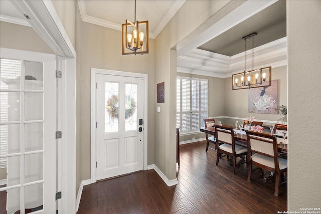 entrance foyer with crown molding, dark wood finished floors, and an inviting chandelier