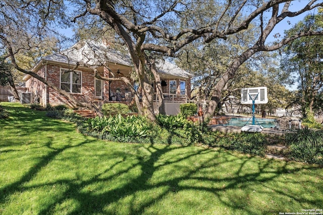 view of yard with ceiling fan and an outdoor pool