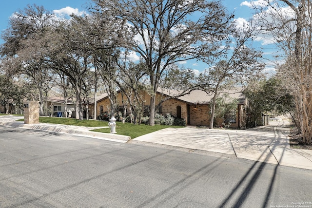 ranch-style home featuring brick siding and a front lawn