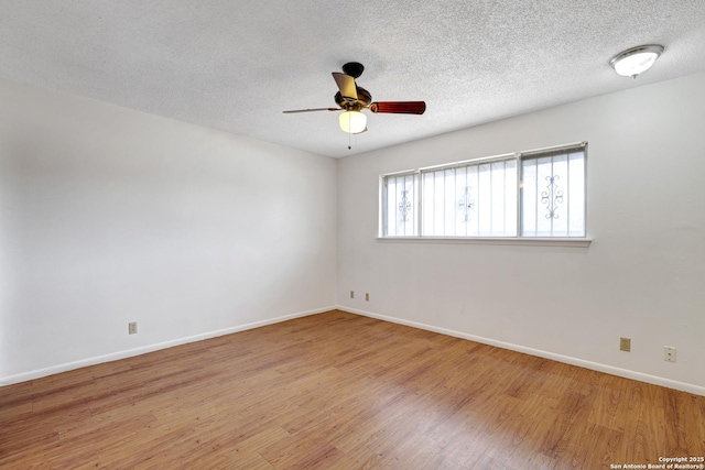 empty room featuring ceiling fan, a textured ceiling, wood finished floors, and baseboards