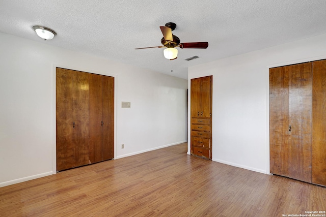 unfurnished bedroom with baseboards, visible vents, and wood finished floors