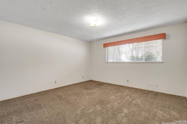 carpeted spare room with a textured ceiling