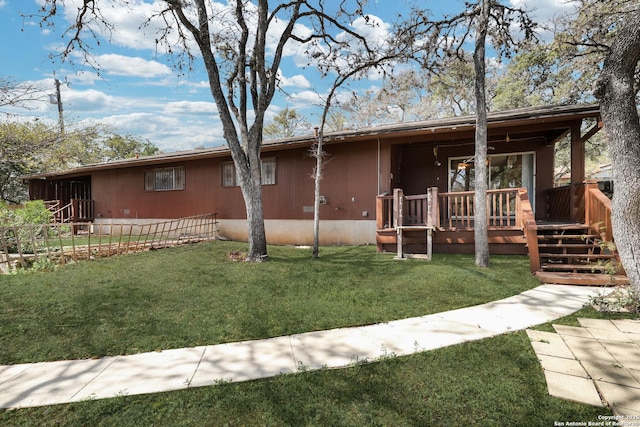 single story home with a front yard and a deck