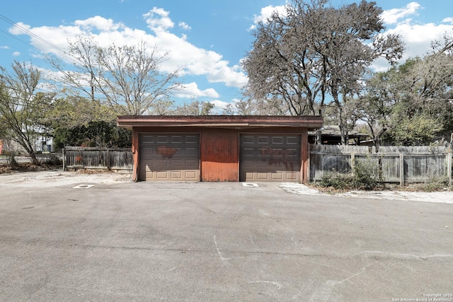 detached garage featuring fence