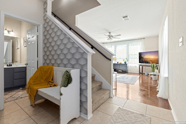 stairs with tile patterned flooring, visible vents, and ceiling fan