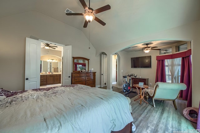 bedroom featuring arched walkways, lofted ceiling, visible vents, ceiling fan, and wood finished floors