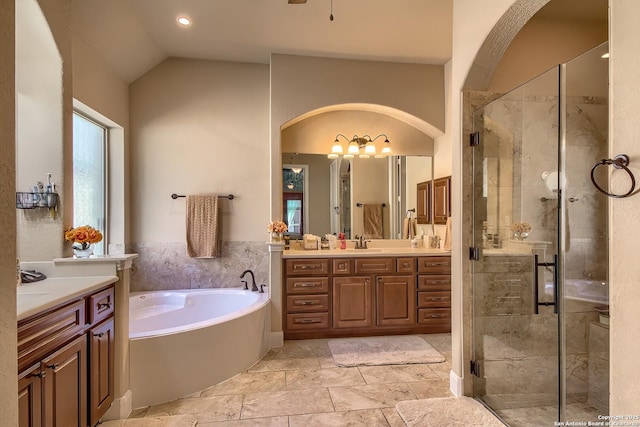 bathroom featuring lofted ceiling, a stall shower, a garden tub, and vanity