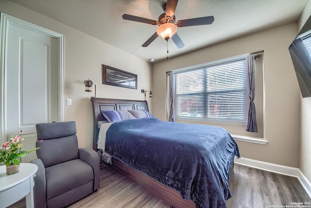 bedroom featuring ceiling fan, wood finished floors, and baseboards