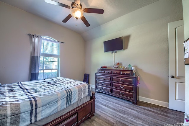 bedroom with a ceiling fan, baseboards, vaulted ceiling, and dark wood-style flooring