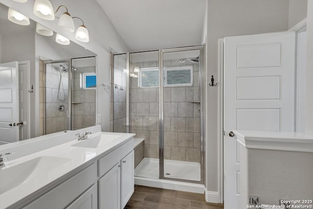 bathroom with a stall shower, a sink, and wood tiled floor