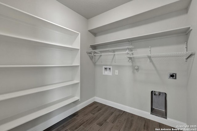 washroom with dark wood finished floors, hookup for a washing machine, hookup for an electric dryer, gas dryer hookup, and laundry area