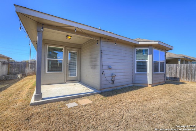 back of house with a yard, a patio area, and a fenced backyard