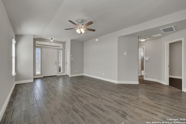 unfurnished living room with dark wood-style floors, visible vents, ceiling fan, and baseboards