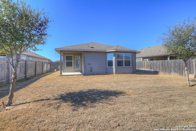 back of house featuring a patio, a lawn, and a fenced backyard