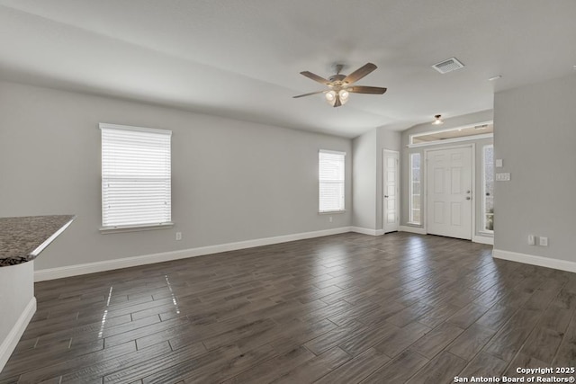 unfurnished living room featuring a ceiling fan, baseboards, visible vents, and dark wood-type flooring