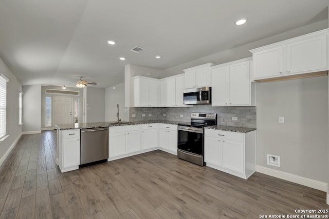 kitchen featuring a peninsula, visible vents, appliances with stainless steel finishes, and backsplash