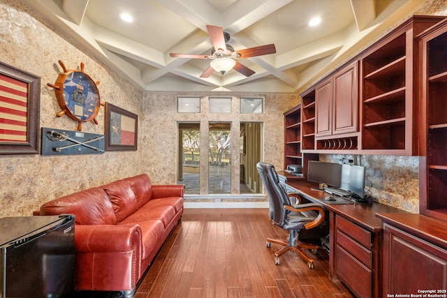 office space with wallpapered walls, coffered ceiling, built in study area, dark wood-style flooring, and beamed ceiling