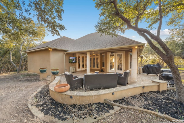 rear view of house featuring a patio, french doors, a shingled roof, and an outdoor living space