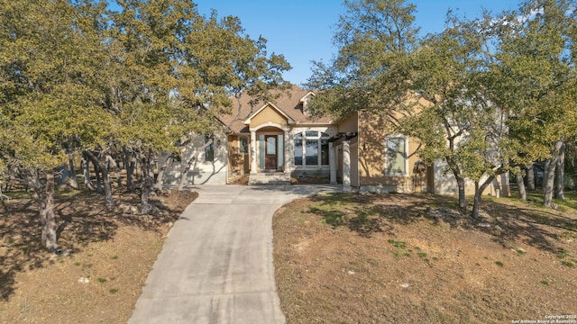 view of front of home featuring concrete driveway and stucco siding