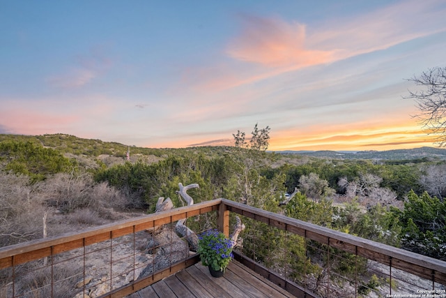 deck at dusk featuring a mountain view