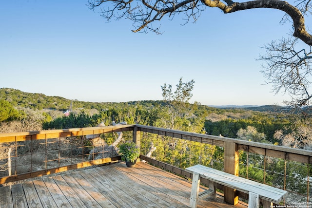 wooden deck featuring a mountain view and a view of trees