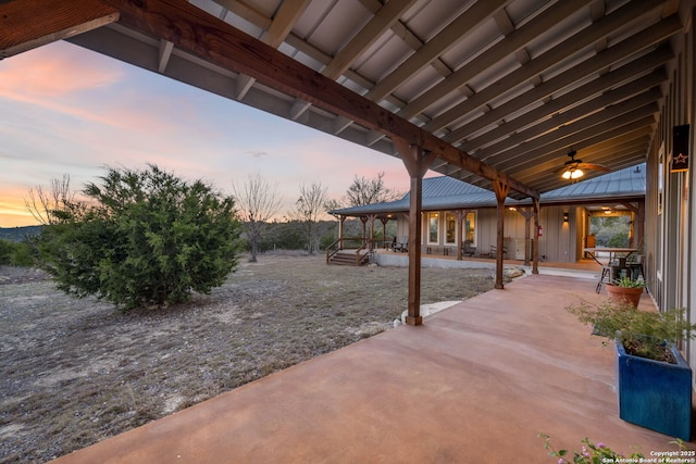 patio terrace at dusk featuring ceiling fan