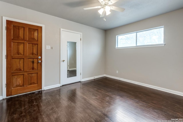 empty room with wood finished floors, a ceiling fan, and baseboards