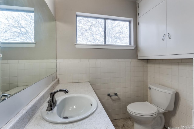 bathroom featuring toilet, tile walls, and vanity