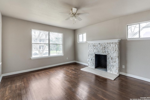 unfurnished living room with a fireplace, baseboards, and wood finished floors