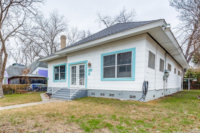 rear view of house with crawl space, a yard, a chimney, and french doors