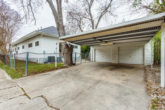 exterior space with central AC unit, a detached garage, and fence