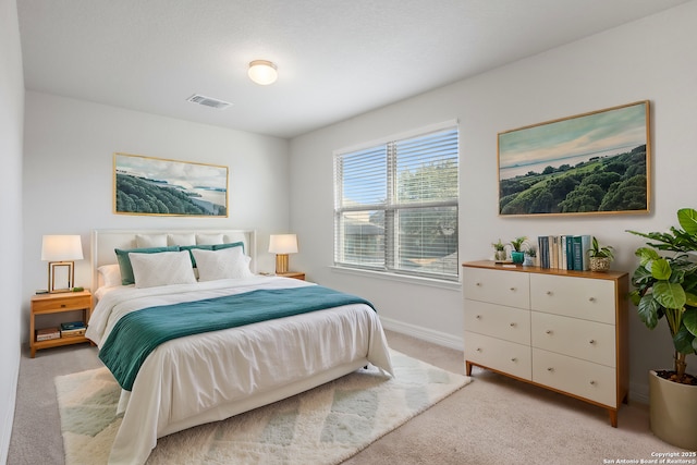 bedroom with light carpet, visible vents, and baseboards