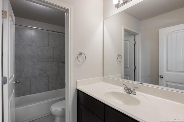 bathroom featuring a textured ceiling, bathtub / shower combination, vanity, and toilet