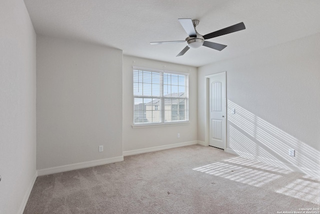 carpeted empty room featuring a textured ceiling, baseboards, and a ceiling fan